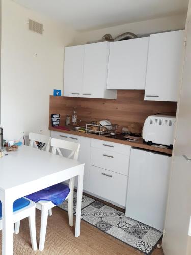 une cuisine avec des placards blancs et une table et des chaises blanches dans l'établissement BEAUMER - Men Dû, Parking, Wifi - UD96, à Carnac