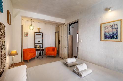 a living room with a bed and orange chairs at La lechuga azul in Güéjar-Sierra
