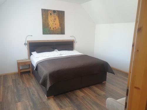 Bett in einem Schlafzimmer mit Holzboden in der Unterkunft Ferienhaus Apetlon in Apetlon