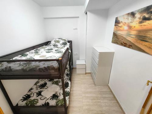 a small room with a bunk bed and a painting at Sea view apartment in Cullera