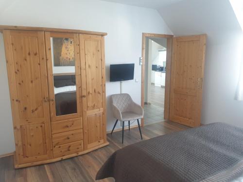 a bedroom with a large wooden cabinet and a chair at Ferienhaus Apetlon in Apetlon