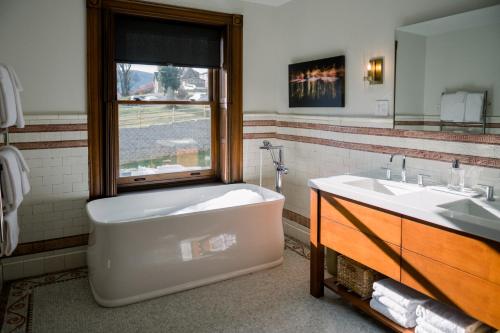 a bathroom with a tub and a sink and a window at Wilbur Mansion in Bethlehem