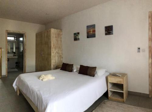 ein Schlafzimmer mit einem weißen Bett mit einem Hund, der darauf liegt in der Unterkunft Amalfi Villa in Grand Baie