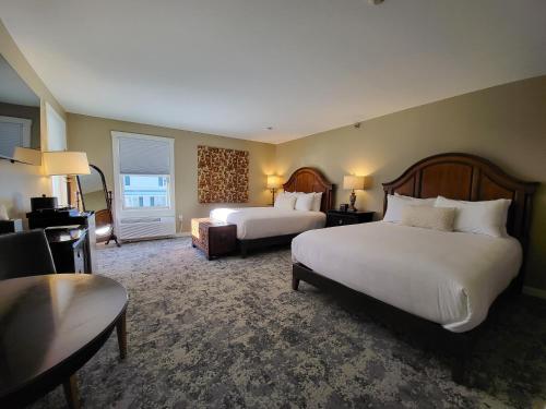 um quarto de hotel com duas camas e uma sala de estar em The Stowe Village Inn em Stowe