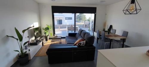 sala de estar con sofá azul y mesa en Chalet con piscina, terraza y barbacoa en Pallaresos