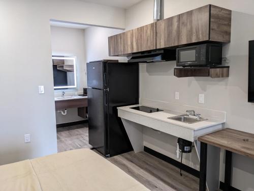 een keuken met een wastafel en een zwarte koelkast bij Captain Suites in Baytown