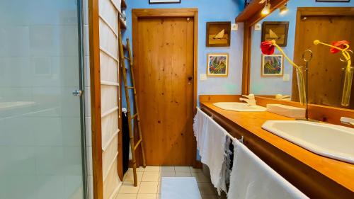 une salle de bain avec deux lavabos et une douche dans l'établissement jolie maison de vacances a proximitée du port et des commerces et de la plage, à La Flotte