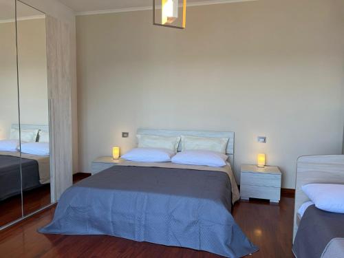 a bedroom with a bed with two lamps and a mirror at Vip sul mare in Castellammare di Stabia