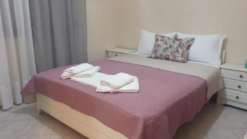 a bedroom with a bed with two towels on it at Evelyn Home in Limenas