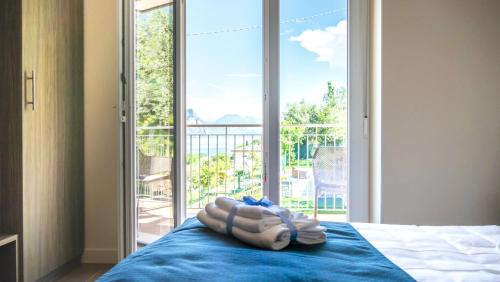 a bedroom with a bed and a large window at Hotel Casa Marinella in Malcesine