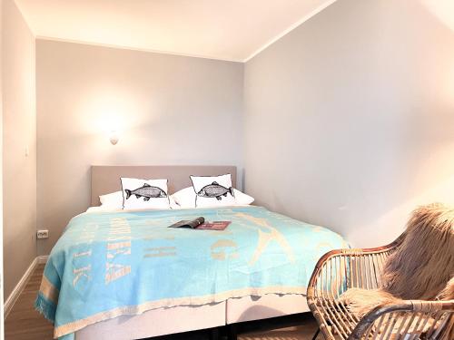 um quarto com uma cama e uma cadeira em Sylter Residenz App 43 mit Meerblick em Westerland