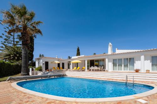 a villa with a swimming pool in front of a house at Casa Igreja in Carvoeiro