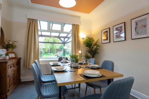 a dining room with a table and chairs and a window at Strawberry Fields House - Air Host & Stay - 3 Bedroom in Liverpool