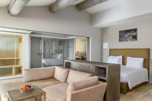 een woonkamer met een bed en een bank bij Coquillade Provence in Gargas
