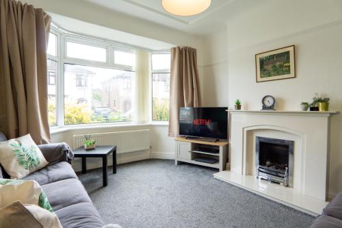 a living room with a couch and a fireplace at Strawberry Fields House - Air Host & Stay - 3 Bedroom in Liverpool