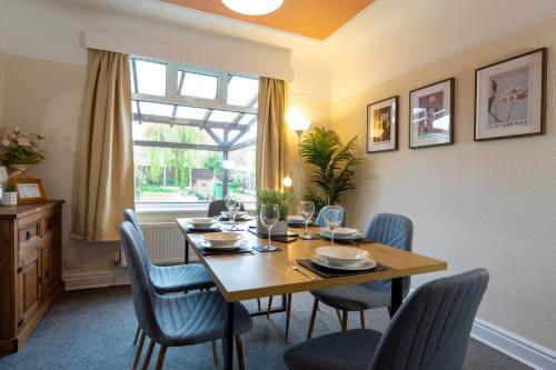 a dining room with a table and chairs and a window at Strawberry Fields House - Air Host & Stay - 3 Bedroom in Liverpool