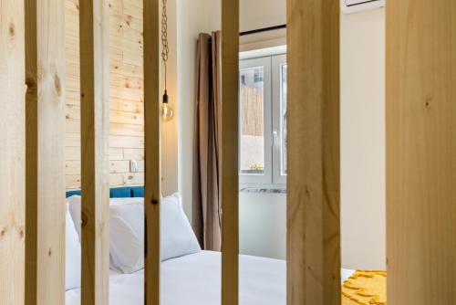 um quarto com paredes de madeira, uma cama e uma janela em Sé Apartamentos - Liberdade 546 Apartments em Braga