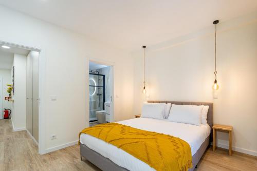 a bedroom with a large bed with a yellow blanket at Liberdade 546 Family Apartment By Sé Apartamentos in Braga