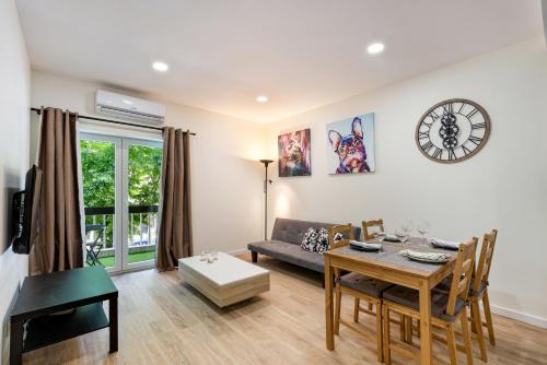 a living room with a table and a clock on the wall at Liberdade 546 Family Apartment By Sé Apartamentos in Braga