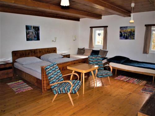 RůžováにあるCHALUPA AROSAのベッドルーム1室(ベッド1台、テーブル、椅子付)