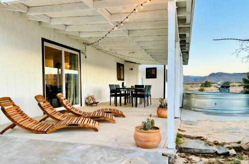 a patio with chairs and a table and a dining room at Ravens Nest Ranch, Fire pit , Views, Near JT Park! in Joshua Tree