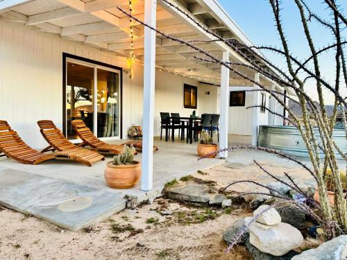 a porch of a house with chairs and a table at Ravens Nest Ranch, Fire pit , Views, Near JT Park! in Joshua Tree