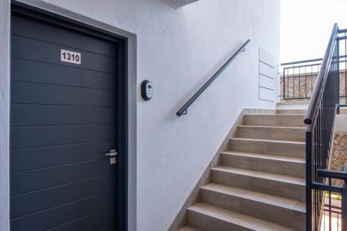 a black door with a number on it next to stairs at Unit 1310 The Blyde in Boschkop