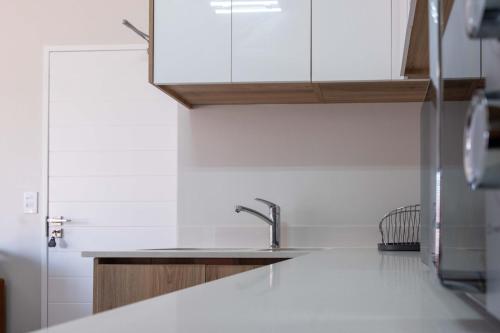 a kitchen with white cabinets and a sink at Unit 1310 The Blyde in Boschkop