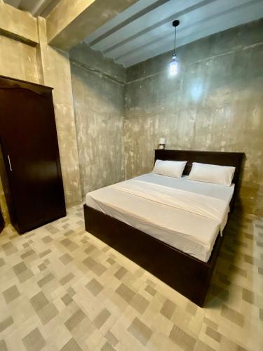 a bedroom with a bed with white sheets and pillows at Hai Inn in Dumaguete