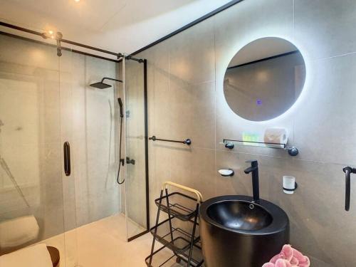 uma casa de banho com um lavatório e um chuveiro com um espelho. em Key View - Torch Tower em Dubai