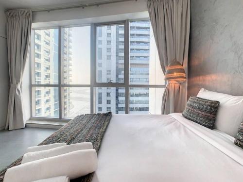 um quarto com uma cama grande e uma janela grande em Key View - Torch Tower em Dubai