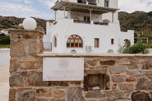 a white building with a sign in front of it at Orkos Naxian Wave 3 in Mikri Vigla