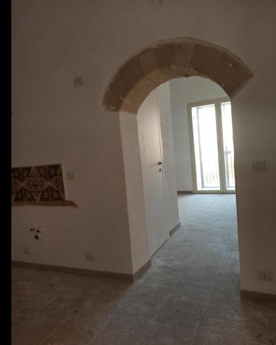 an empty room with an archway and a door at Casa cara al porto n. 26 in Bari