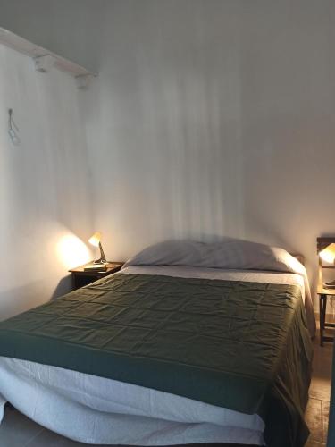 a bedroom with a bed with a green comforter at Casa cara al porto n. 26 in Bari