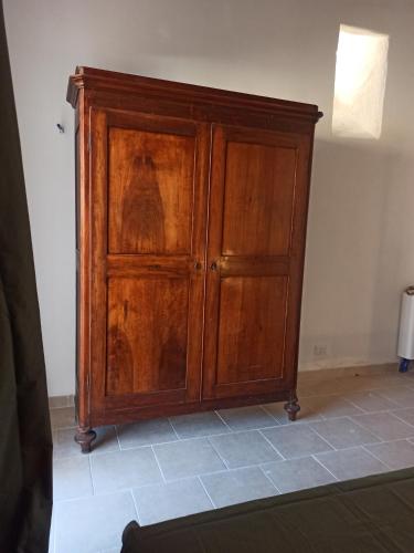 a wooden cabinet in the corner of a room at Casa cara al porto n. 26 in Bari