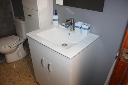 ein Badezimmer mit einem weißen Waschbecken und einem WC in der Unterkunft Wimpy Solo Familias Serviplaya in Casas Las Basas