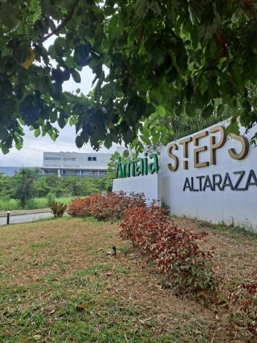 um sinal para a planta anarmaarmaarma com um edifício ao fundo em Amaia Steps Altaraza by GEMcondotel em Tunkong Manga