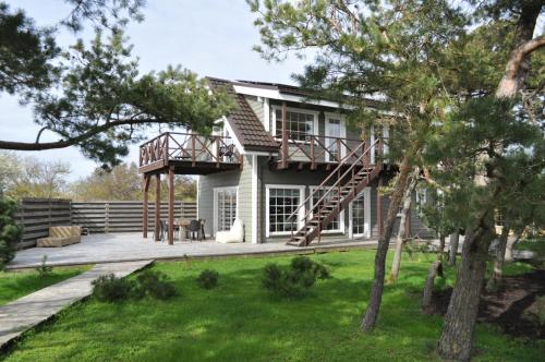 a house with a porch and a deck at Kopa Jura apartment on the beach in Palanga