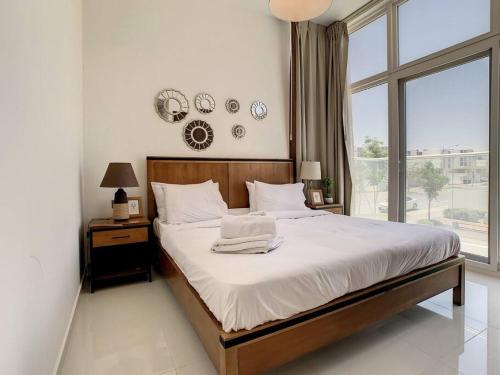 a bedroom with a large bed and a large window at Key View - Pacifica, Damac Hills 2 in ‘Ūd al Bayḑāʼ