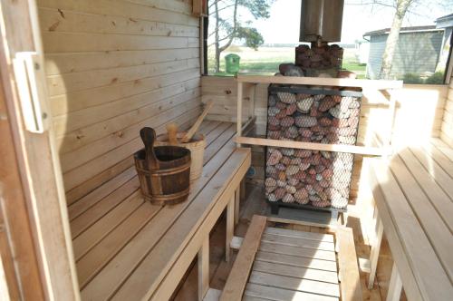 a wooden cabin with a bench and a stove at Kopa Jura apartment on the beach in Palanga