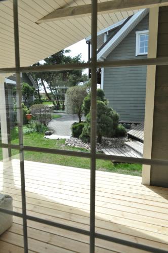 a screened porch with a view of a yard at Kopa Jura apartment on the beach in Palanga