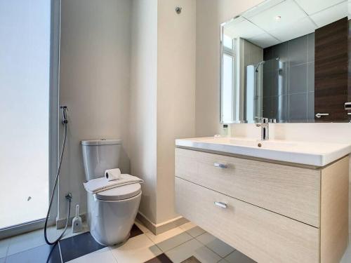 a bathroom with a toilet and a sink and a mirror at Key View - Pacifica, Damac Hills 2 in ‘Ūd al Bayḑāʼ