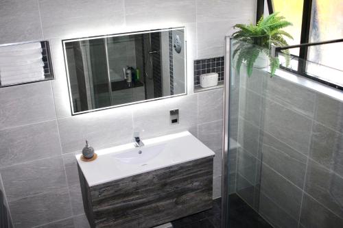 a bathroom with a sink and a mirror at Fairways Villa Newcastle in Newcastle