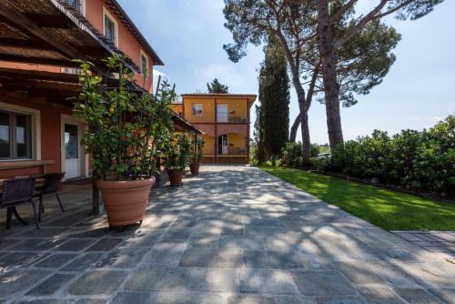 a patio with potted plants and a house at Agriturismo Corte Benedetto in Montecarlo