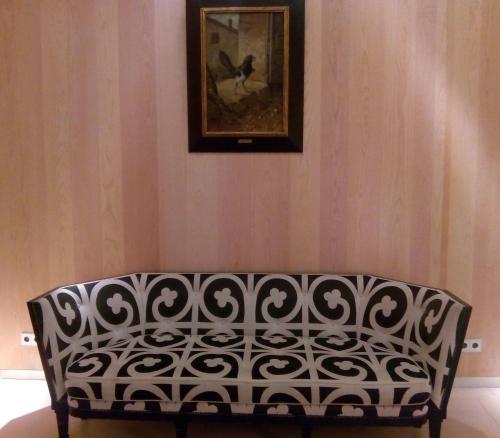 a black and white bench in a room with a painting at Hotel Alfonso in Zaragoza
