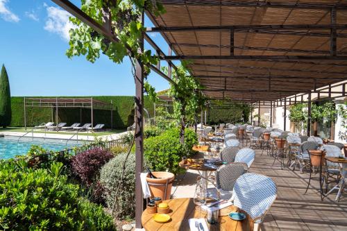 a restaurant with tables and chairs and a pool at Coquillade Provence in Gargas