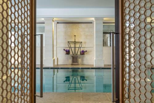 a swimming pool with a table and a vase of flowers at Coquillade Provence - Relais & Châteaux in Gargas