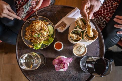 a table with a bowl of noodles and a plate of food at Coquillade Provence - Relais & Châteaux in Gargas