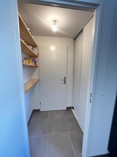 a walk in closet with a door and a tile floor at Amsterdam - Bel appartement in Bezannes-les-Reims
