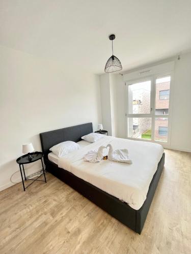 une chambre avec un grand lit avec des draps blancs dans l'établissement Amsterdam - Bel appartement, à Bezannes